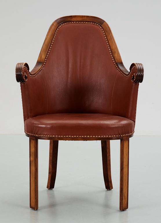 A Swedish easy chair in stained birch, upholstered in artificial leather, by NK, Nordiska Kompaniet, 1910's-20's.