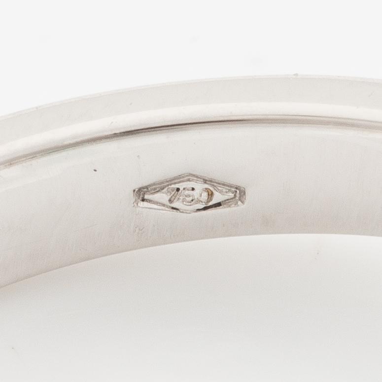 An 18K white gold ring set with an emerald-cut diamond and two step-cut emeralds.