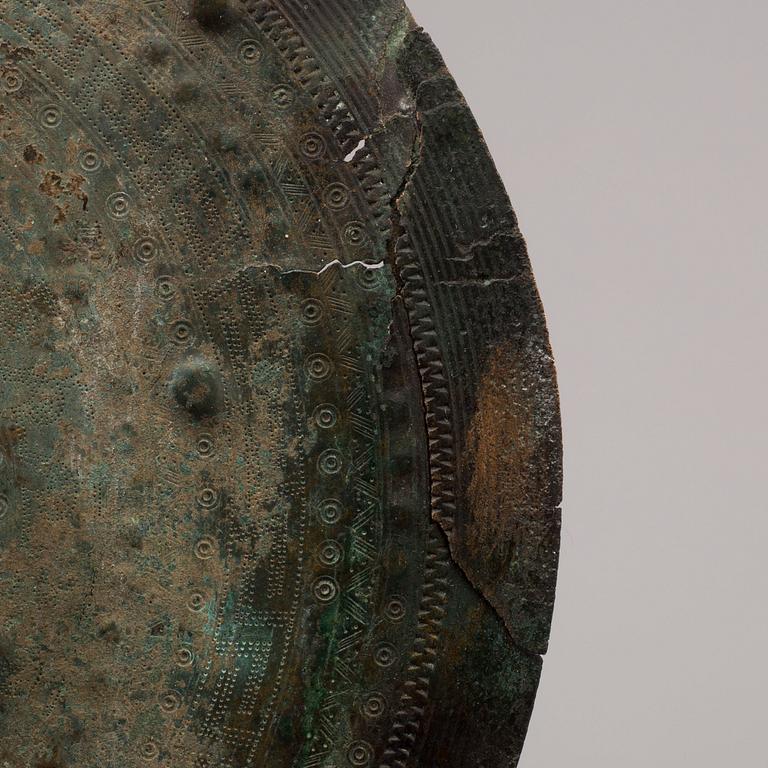 Three 20th century stone objects, with one bronze shield.