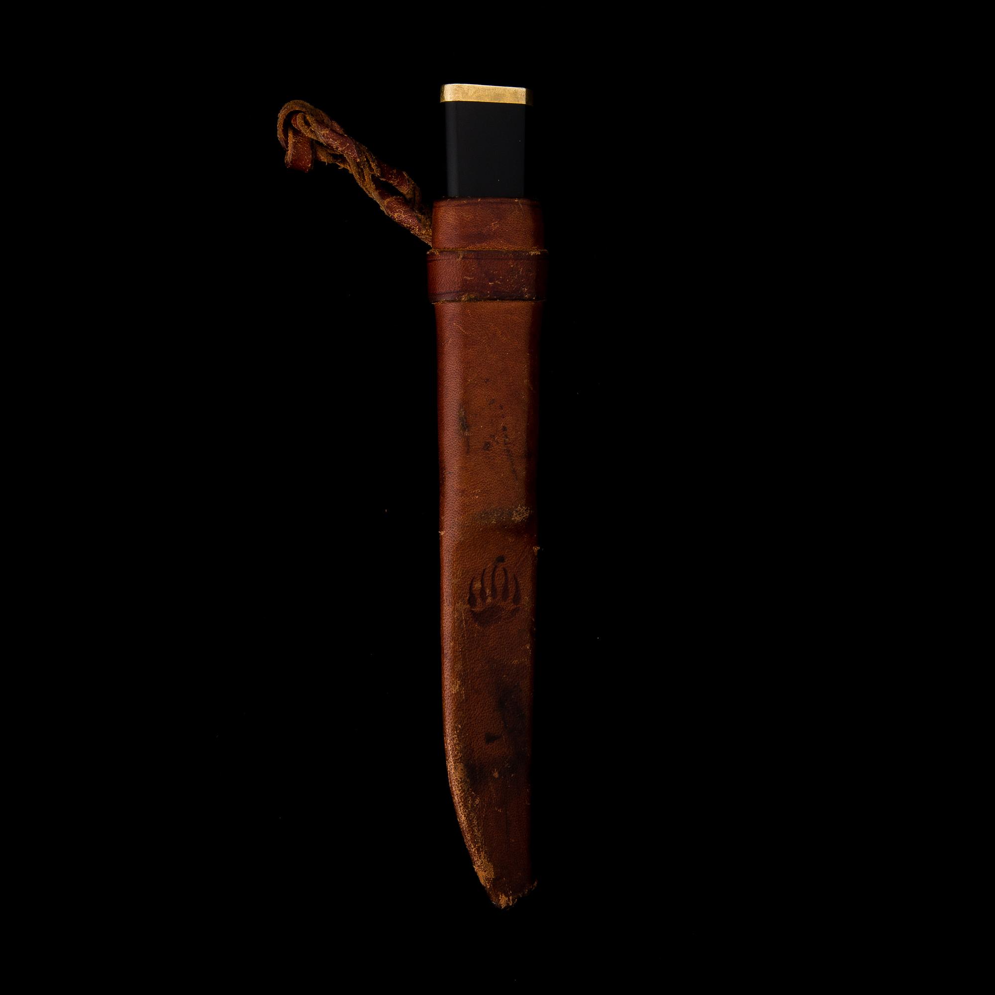 A Finnish puukko knife in stainless steel, nylon and brass designed by Tapio Wirkkala, Hackman Finland.