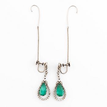 A pair of drop shaped emerald and diamond earrings.