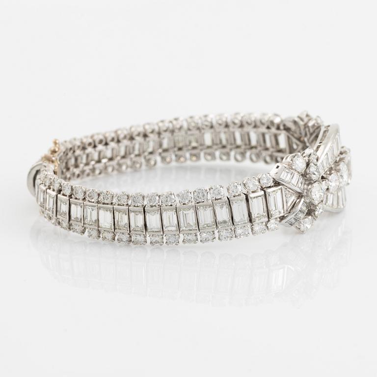 A platinum bracelet set with step-cut and brilliant-cut diamonds.