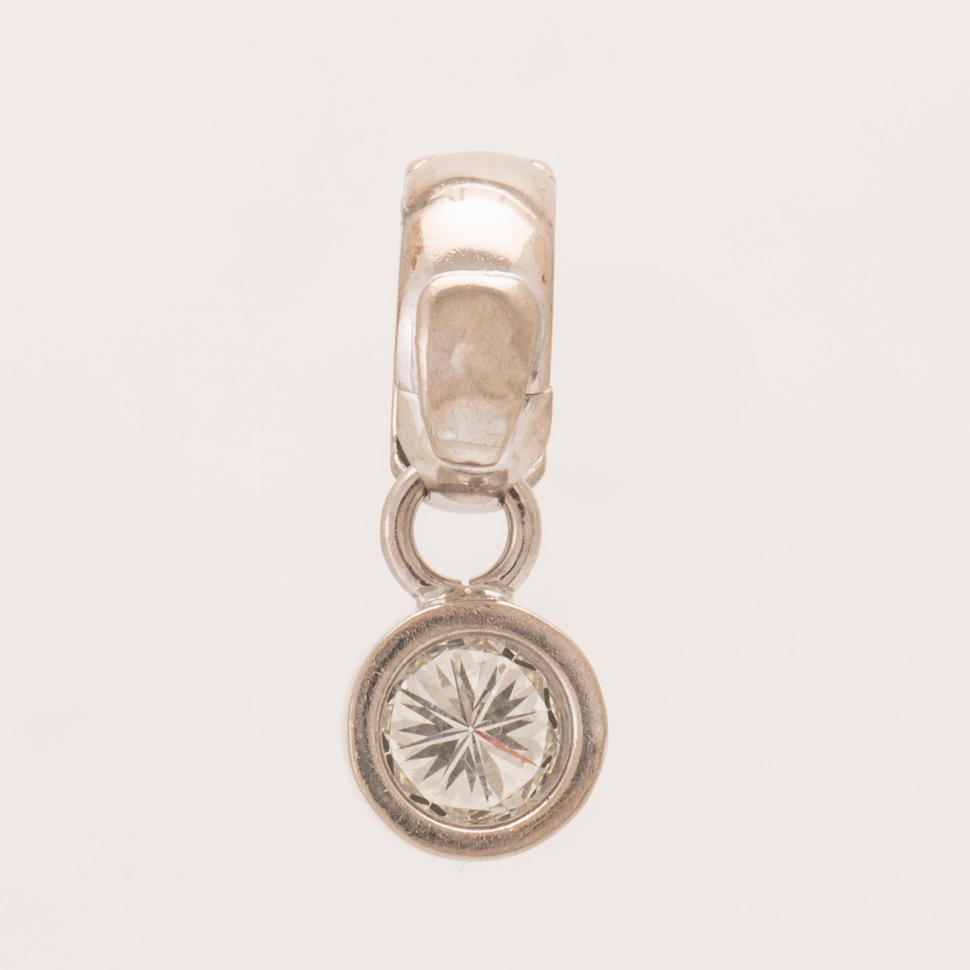 An 18K white gold pendant set with a round brilliant-cut diamond.