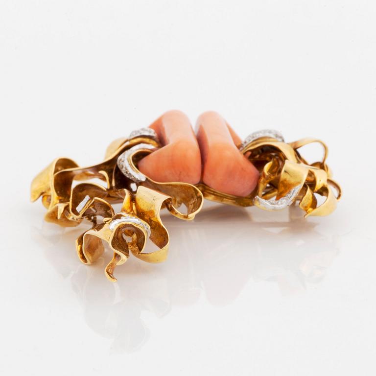 A Kutchinsky brooch in 18K gold set with coral and round brilliant-cut diamonds.