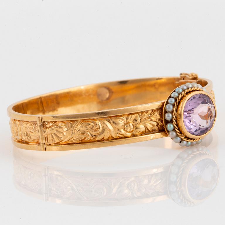 An 18K gold bracelet set with a faceted amethyst and pearls.