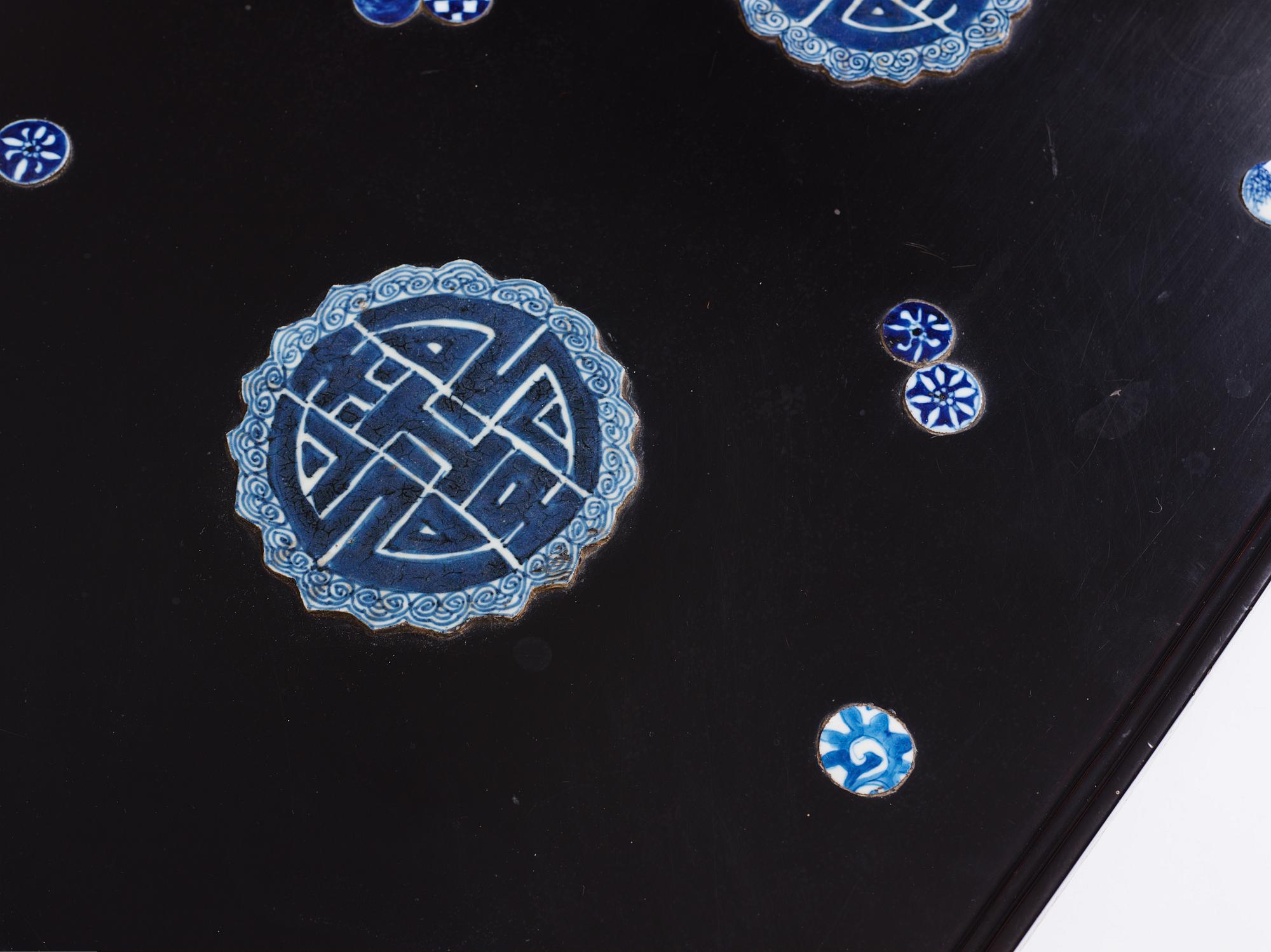A Chinese black lacquered table with porcelain placques, presumably first half of the 20th century.
