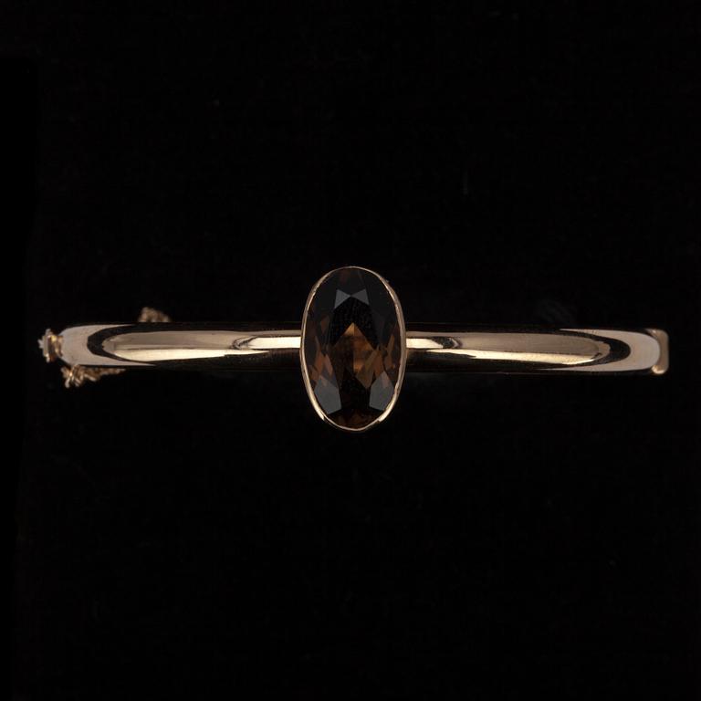 ARMRING, guld 14K med rökkvarts, Eero Rislakki, N. Westerback, Helsingfors 1975. Vikt 9,9 g.