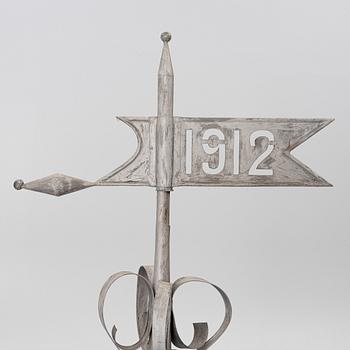 Tower spire with weather vane dated 1912.