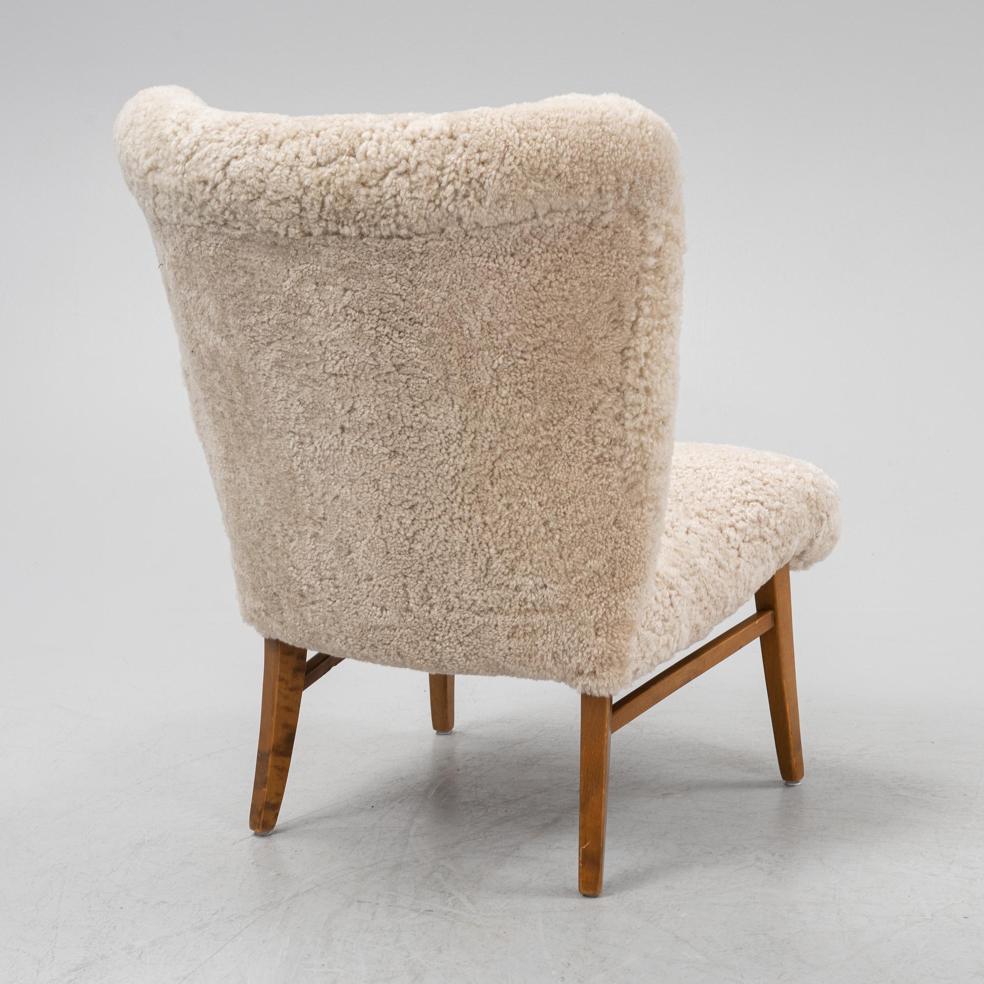 A mid 20th Century easy chair with sheepskin upholstery.