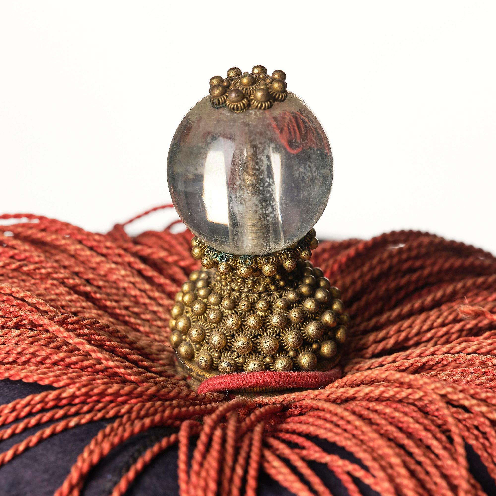 Two boxes with a mandarin's summer hat and black satin autumn hat and feather with six mandarin hat insignias.