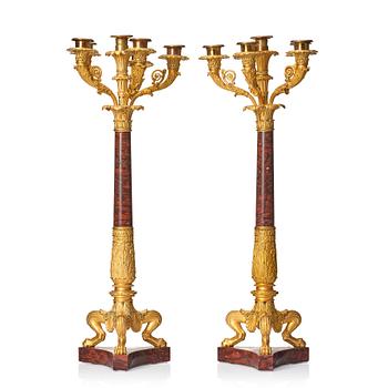 135. A pair of French Empire ormolu and rouge griotte six-branch candelabra, first part of the 18th century.