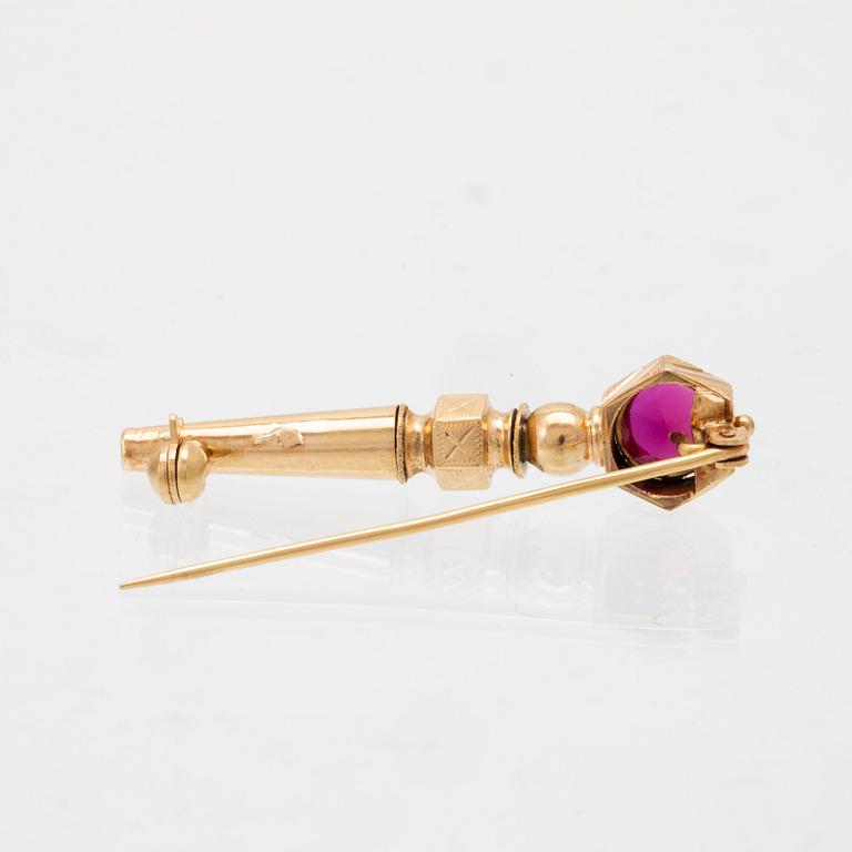 An 18K gold brooch set with a synthetic ruby.