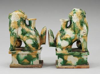 A pair of green and yellow glazed bisquit cencers, in the shape of sitting Buddhist lions, Qing Dynasty, Kangxi (1662-1722).