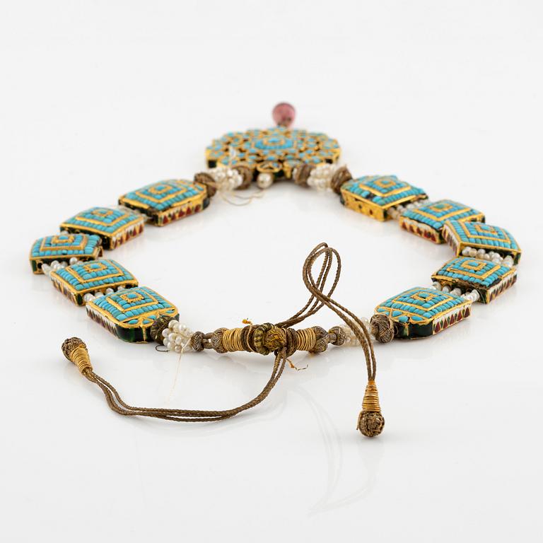 An antique gold and enamel Qajar necklace with pearls set with turquoises and with a garnet drop.