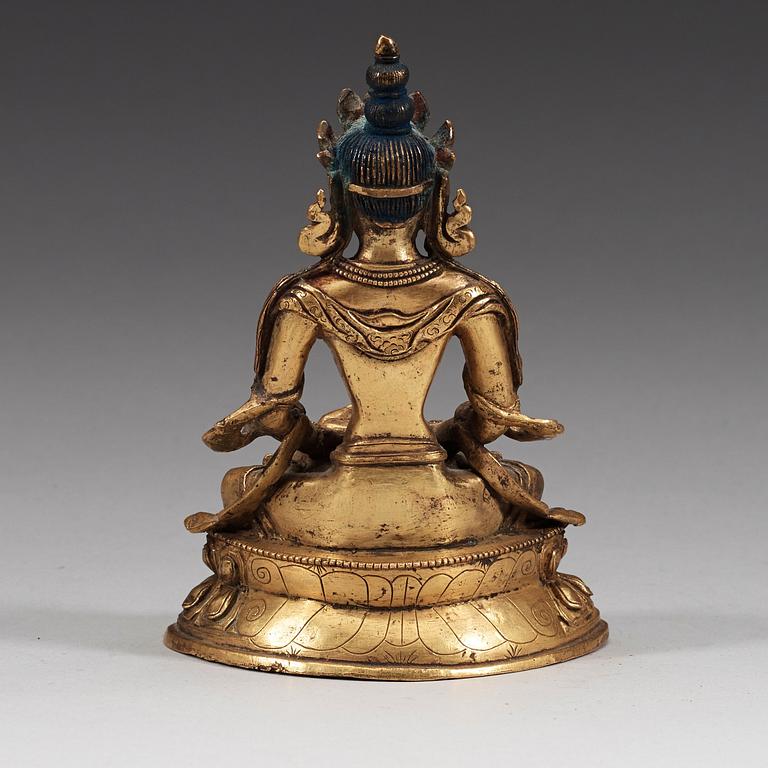 A seated Sino-Tibetan gilt bronze figure of Amitauys, 18th Century.