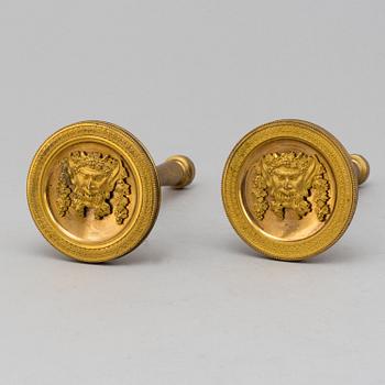 A pair of empire burnt gilt curtain holders, first half of the 20th century.