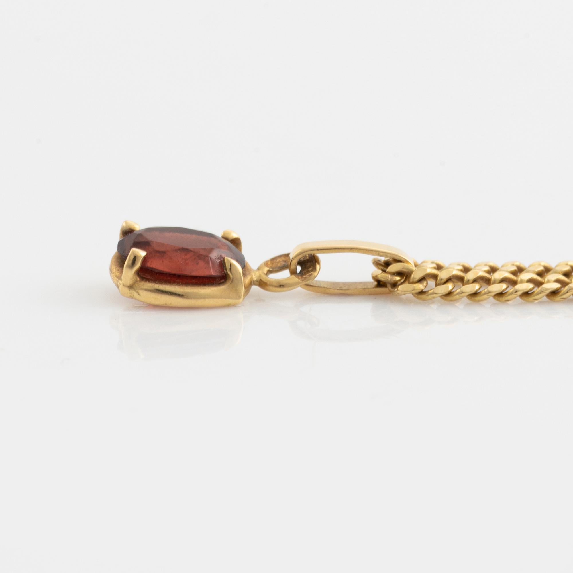 Pendant with chain with red stone, possibly garnet.