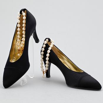 A pair of black silk shoes with pearls by Chanel.