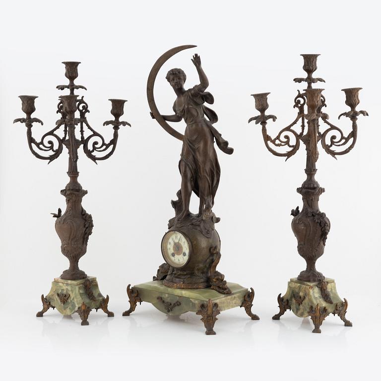 A mantel clock and pair of matching candelabra from the last quarter of the 19th century.