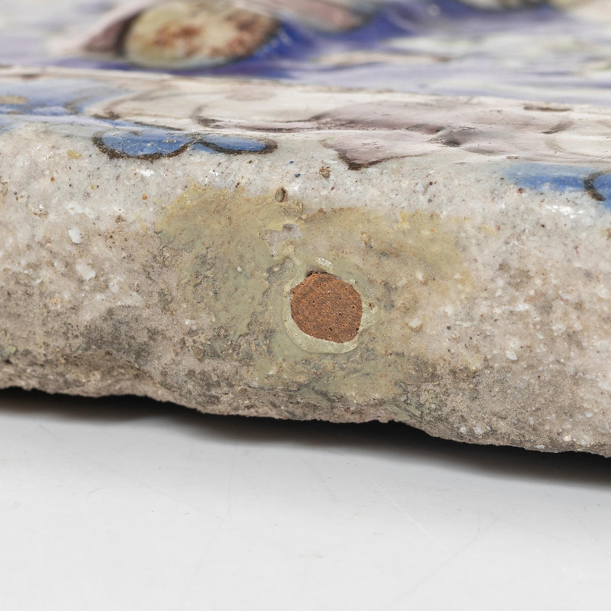 A Qajar moulded figural pottery tile, ca 26 x 19 cm.