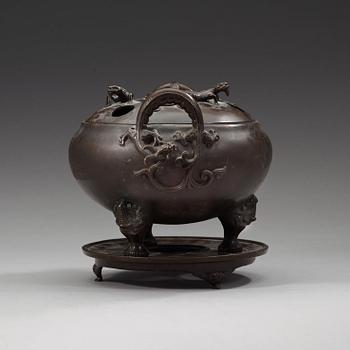 A bronze tripod censer with cover and stand, Qing dynasty, 17/18th Century.