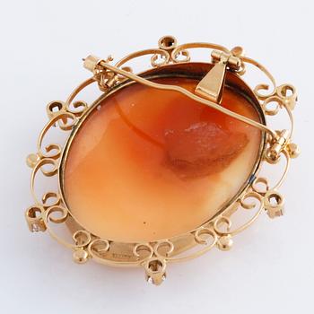 A cameo and white gemstone brooch.