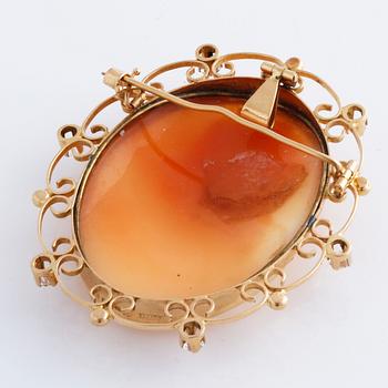 BROSCH/HÄNGE, med skuren snäckskalskamé och vita stenar.