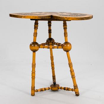 A wooden table from around 1900, cut decor.