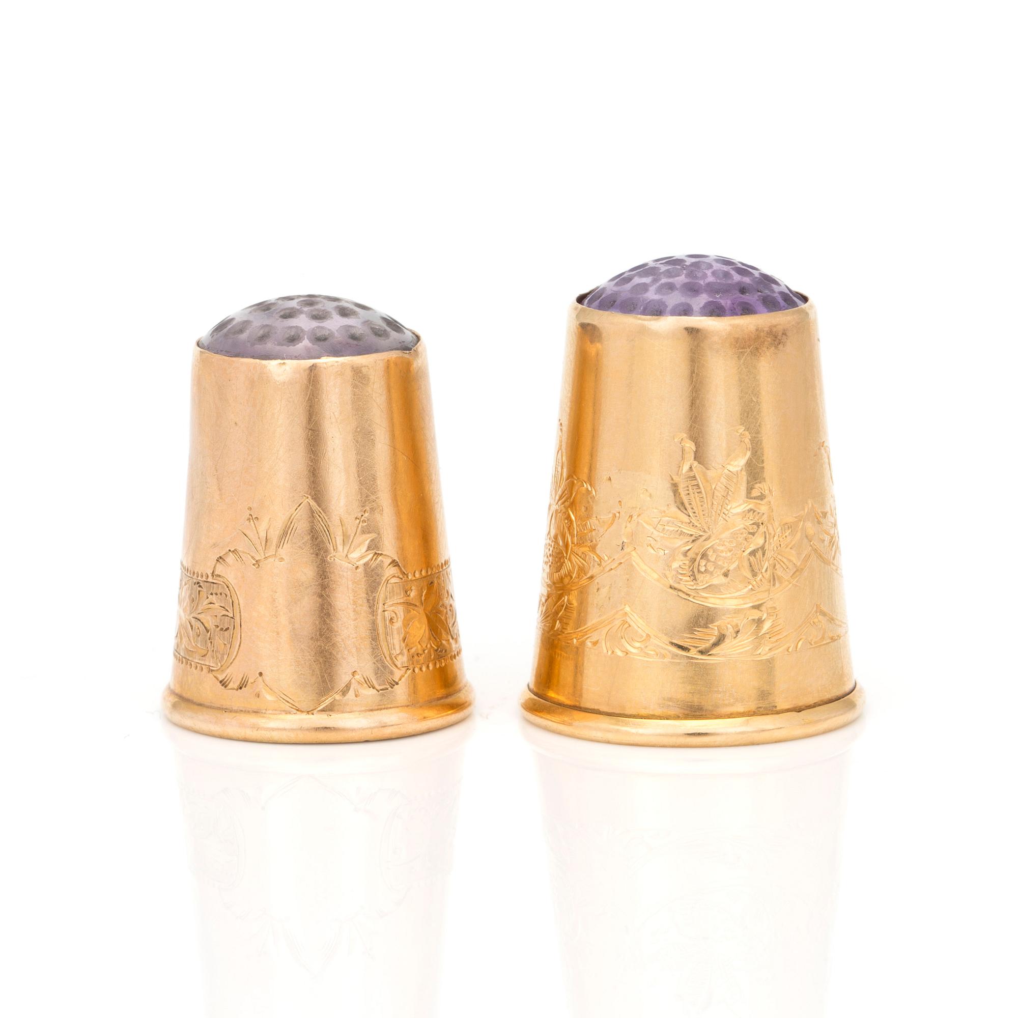 Two 18K gold thimbles with blue and lilac stones.