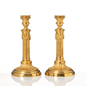 A pair of Louis XVI candlesticks in the manner of Jean Louis Prieurs.