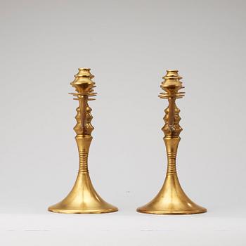 A pair of brass candelabra attributed to Bruno Paul, Germany, early 20th Century.