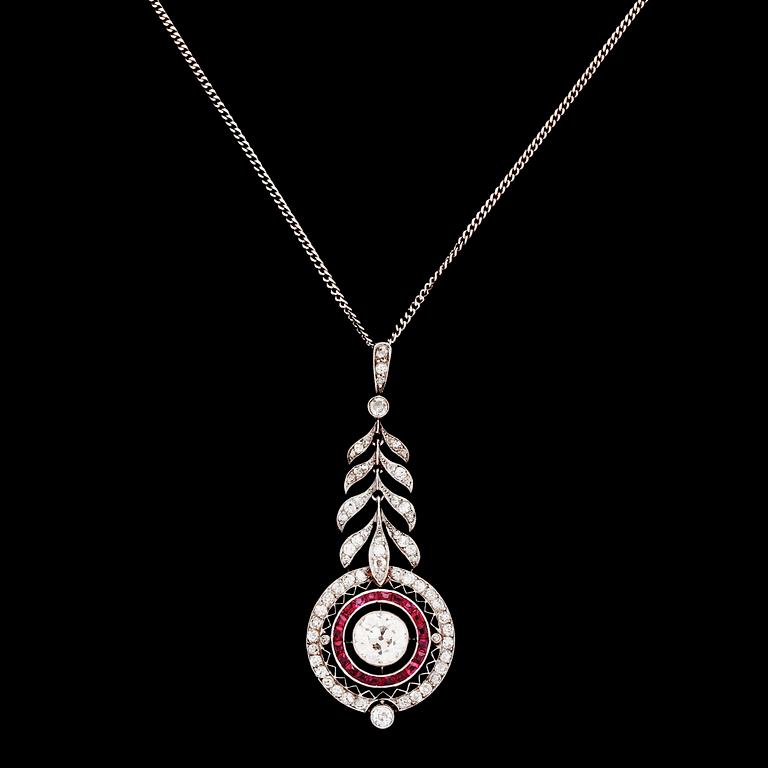 HÄNGSMYCKE, gammalslipad diamant, ca 1 ct, samt krans av carréslipade rubiner och smådiamanter. Ca 1915.