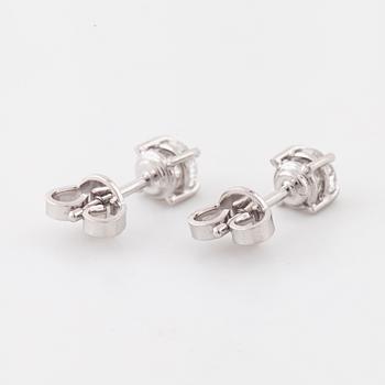 A pair of brilliant cut diamond earrings.