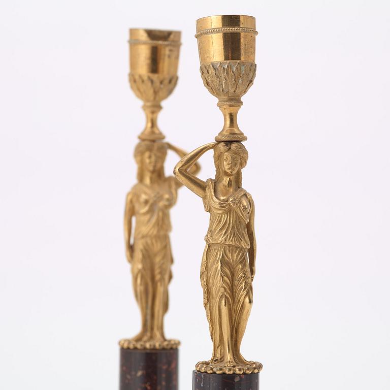 A pair of late gustavian early 19th century porphyry and ormolu candlesticks.