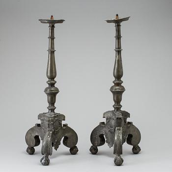 A pair of baroque pewter candlesticks, engraved date 1699.