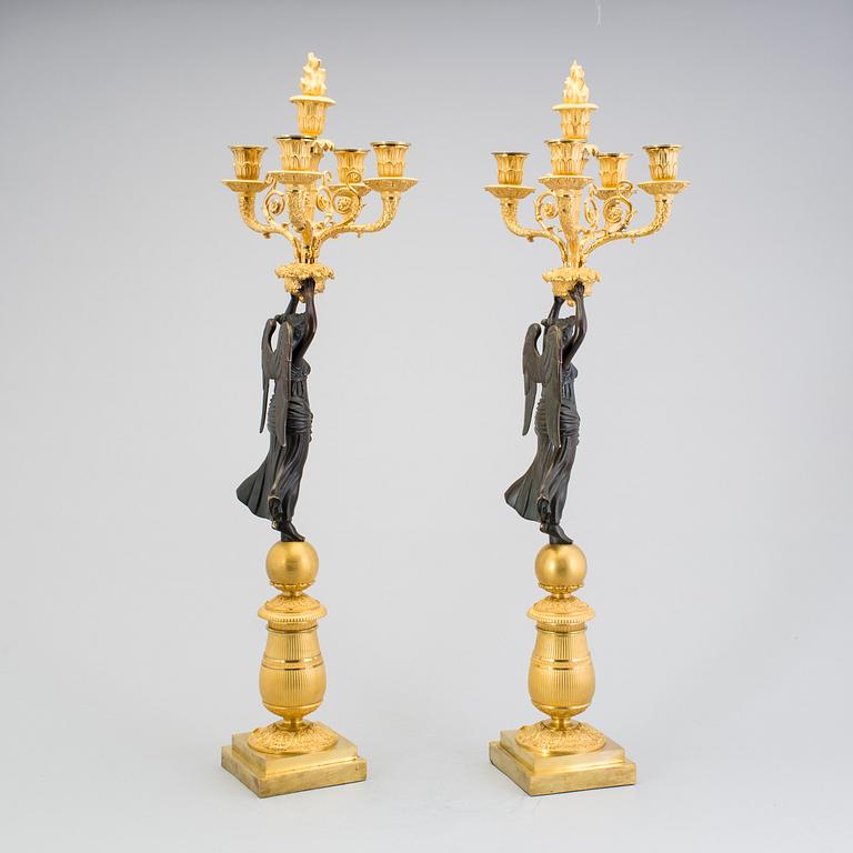 A large pair of first half of the 19th century gilt and patinated bronze five-light candelabra.