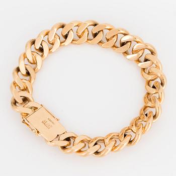 An 18K gold curb link bracelet.