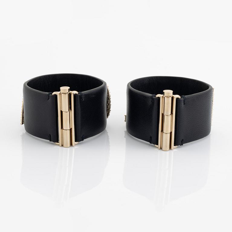 Chanel, a pair of black leather and rhinestone bracelets.