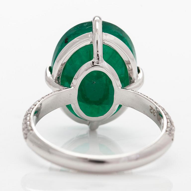 A 14K white gold ring, set with an oval-cut emerald and diamonds. Accompanied with IGI certificate.