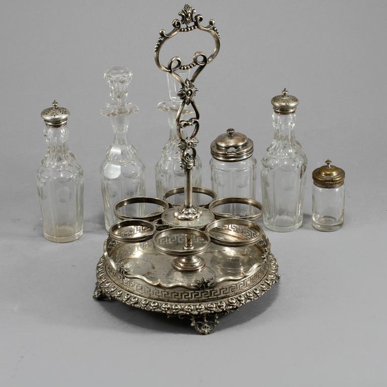 BORDSSURTOUT, 7 delar, vitmetall och glas, omkring år 1900.