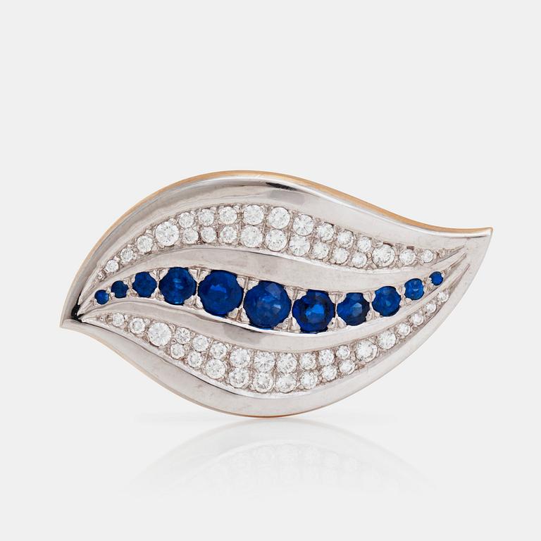 A brooch set with round, mixed-cut sapphires and round, brilliant-cut diamonds.