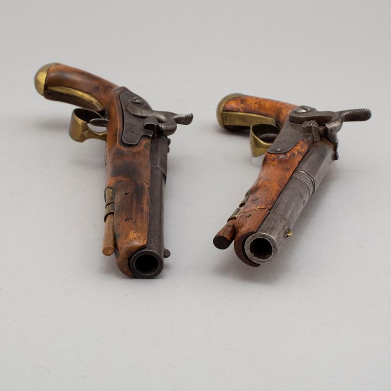 Two Swedish percussion pistols with birch stocks and brass mounts.