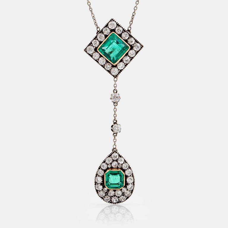A necklace set with two faceted emeralds and old-cut diamonds.