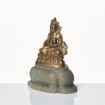 A gilt bronze figure of Amittayus seated on a later base of nephrite, Tibeto-Chinese, late 19th Century.