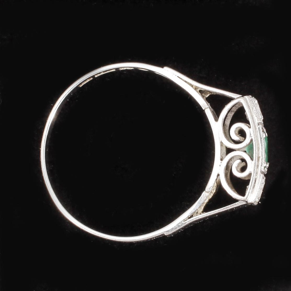 RING, 18k vitguld med briljantslipade diamanter tot ca0,15ct enl gravyr samt smaragd. Vikt 3,5g.
