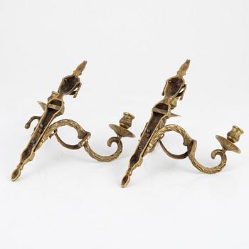 A pair of brass Louis XVI-style two-light wall lights, early 20th Century.