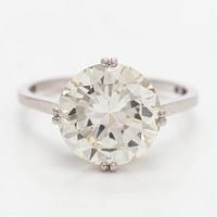 A platinum solitaire ring with a brilliant-cut diamond.