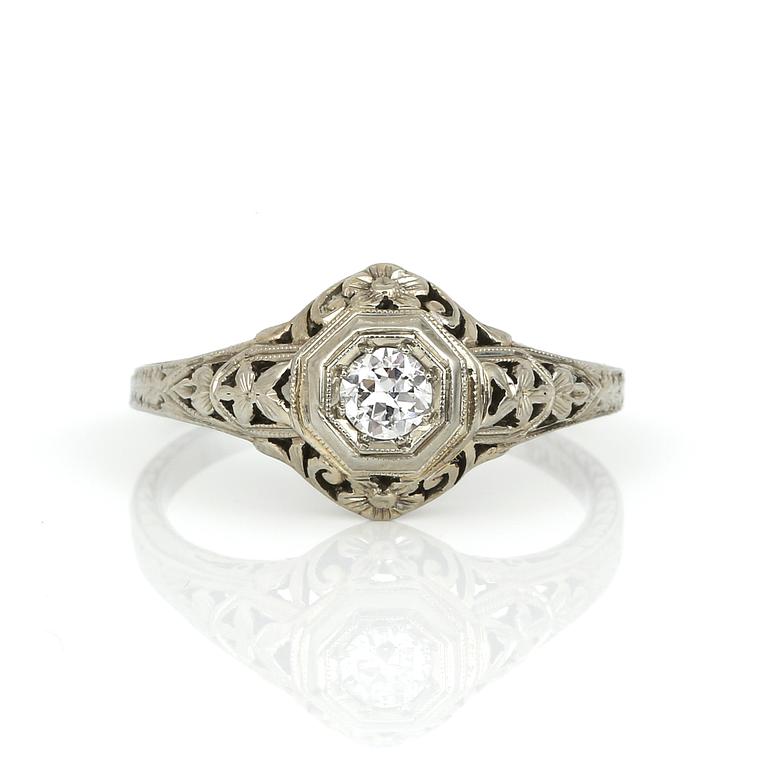 RING, 18K vitguld med briljantslipad diamant ca 0,20 ct, USA, 1900-talets första hälft. Total vikt ca 2,37 g.