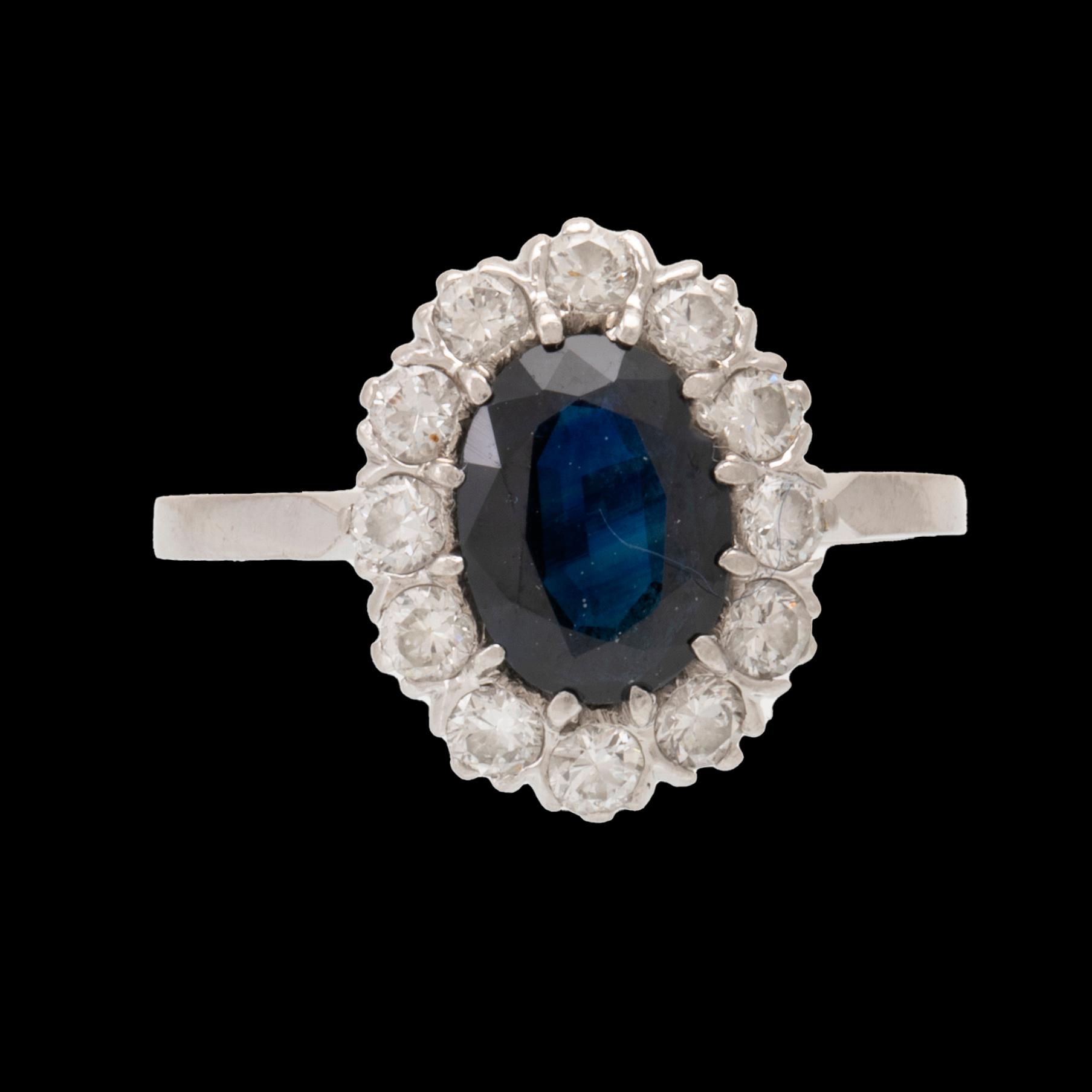 Ring 18K vitguld med oval fasetterad safir samt runda briljantslipade diamanter, Carl Hoff Helsingborg 1973.