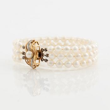 Bracelet, three-stranded with cultured pearls, clasp with a pearl and small diamonds.